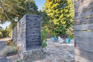 Eine Terrassenfläche mit Adirondack-Stühlen und einer Steinmauer.