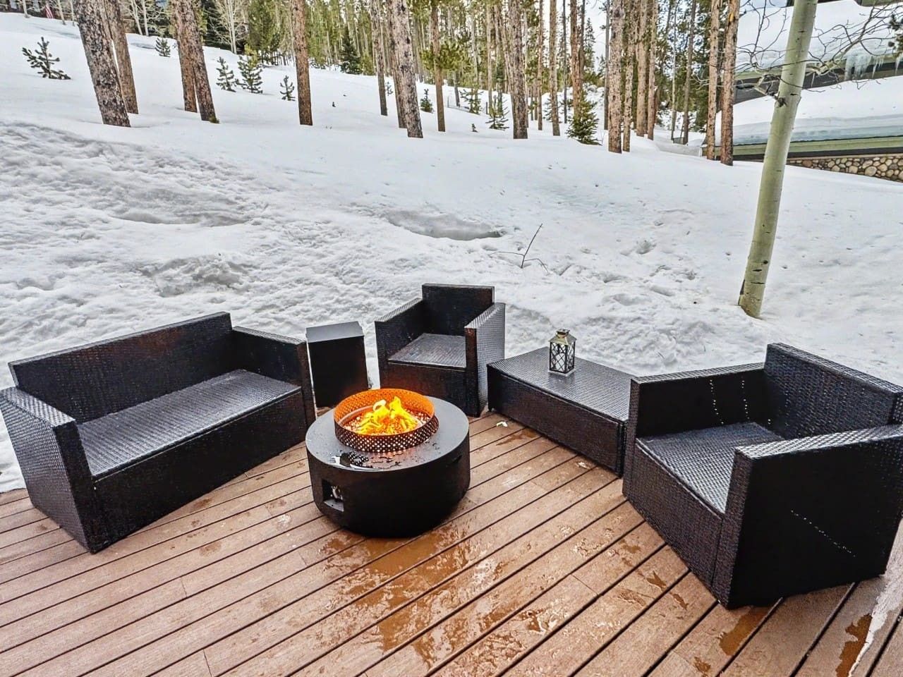 A deck with outdoor furniture and a fire pit.