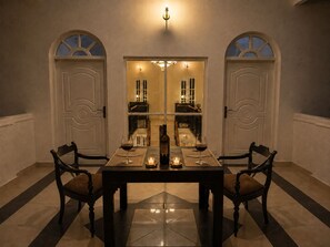 A dining area with a table set for two, two chairs, a candle, and a wine bottle. - ceylon Breeze kandy (Kandy)
