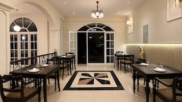 A formal dining area with multiple tables, chairs, and a geometric patterned floor.