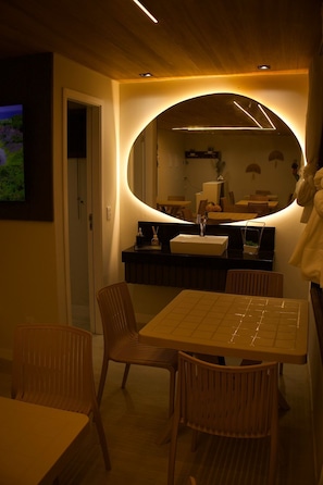 Un interior moderno con comedor, un espejo grande y una encimera de cocina.