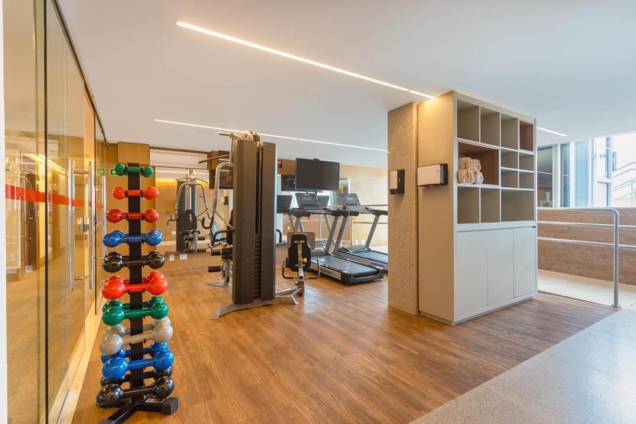 A gym with exercise equipment, a treadmill, and a weight rack.