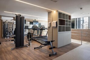 A modern gym with various exercise equipment, including a treadmill and weight machines.