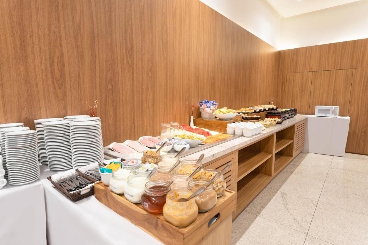 Disposição de buffet com diversos alimentos e utensílios.