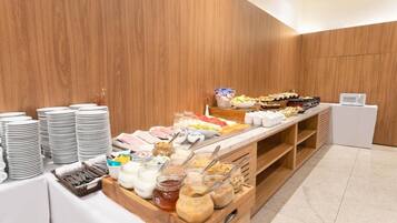 Disposição de buffet com diversos alimentos e utensílios.
