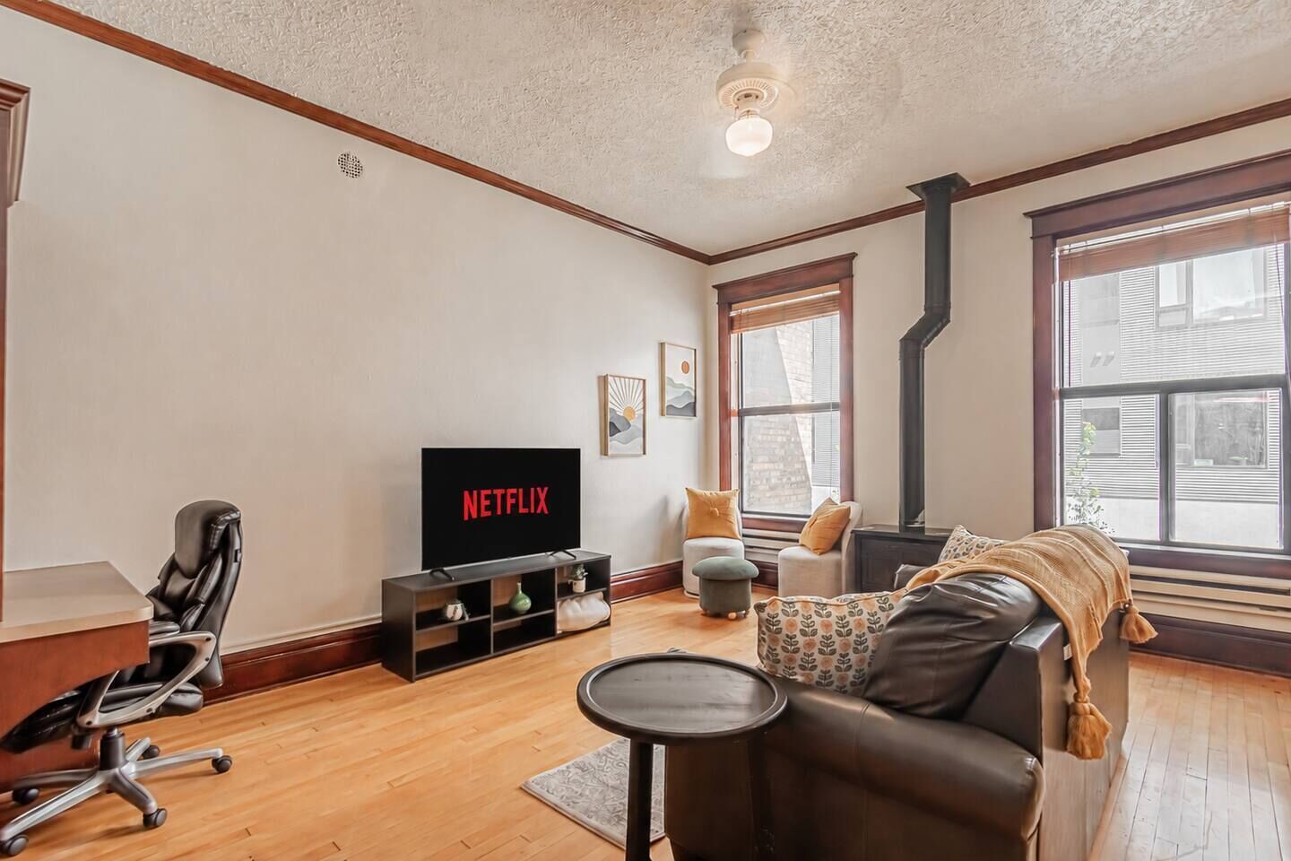 Ein Wohnzimmer mit Fernseher, einer Couch, einem Couchtisch und einem Sessel.