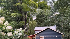 Ett hus med en inglasad uteplats, ett förråd och en gräsmatta.