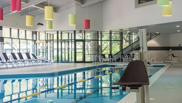Una piscina con corsie, lettini e zona spogliatoi.