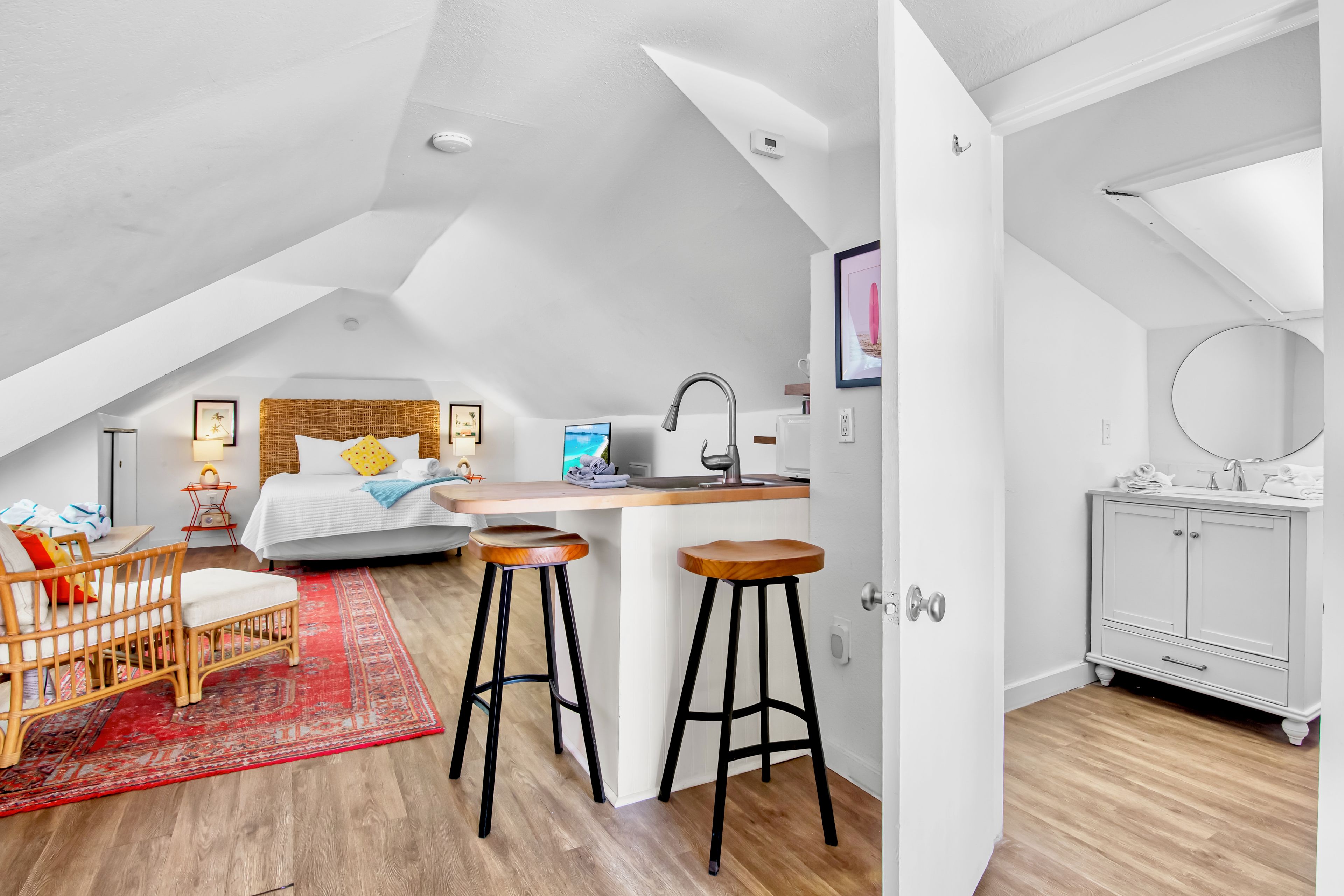 Un apartamento moderno y compacto con un dormitorio tipo loft, kitchenette y un baño.