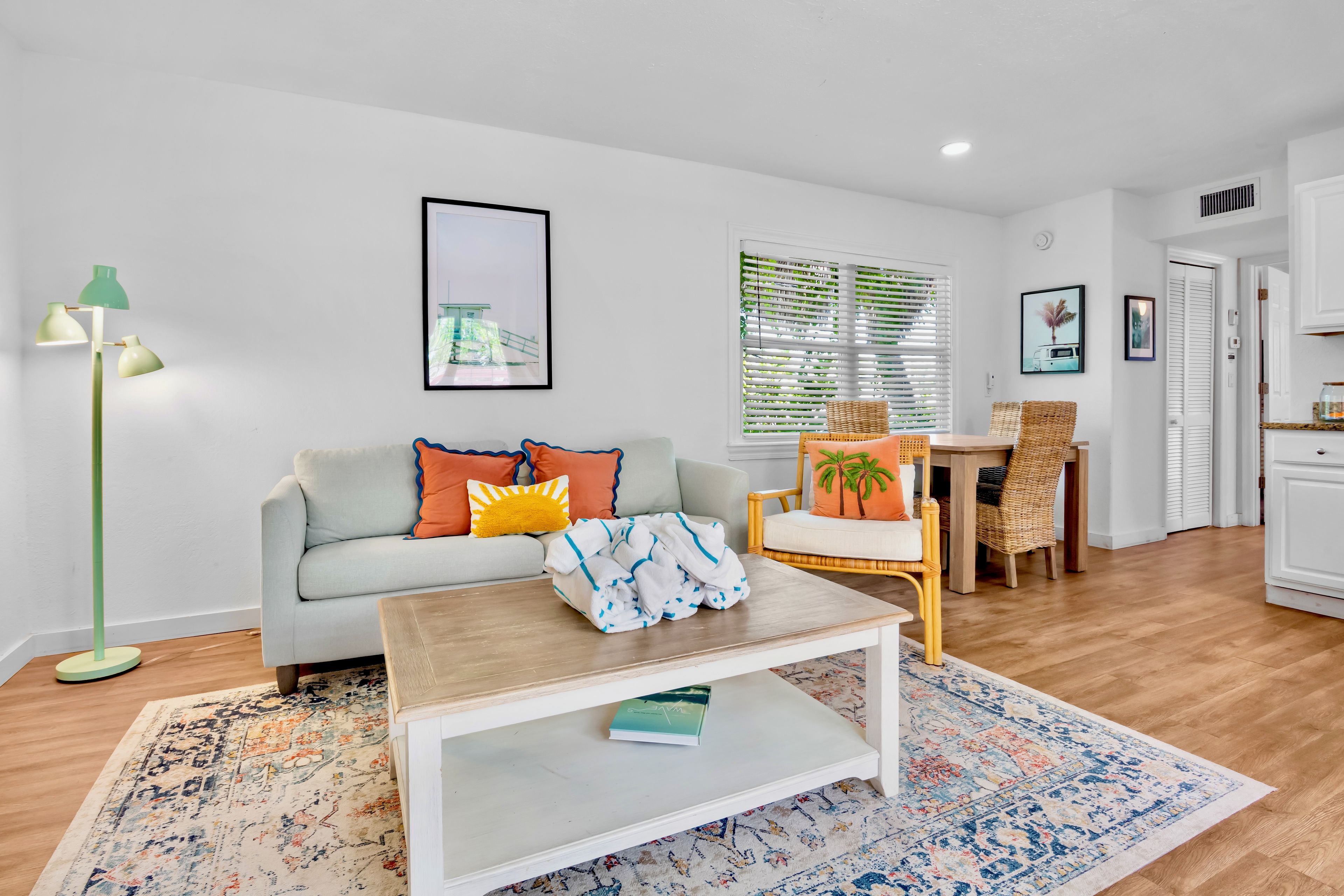 A modern living room with a sofa, coffee table, and a dining area with a chair and table.
