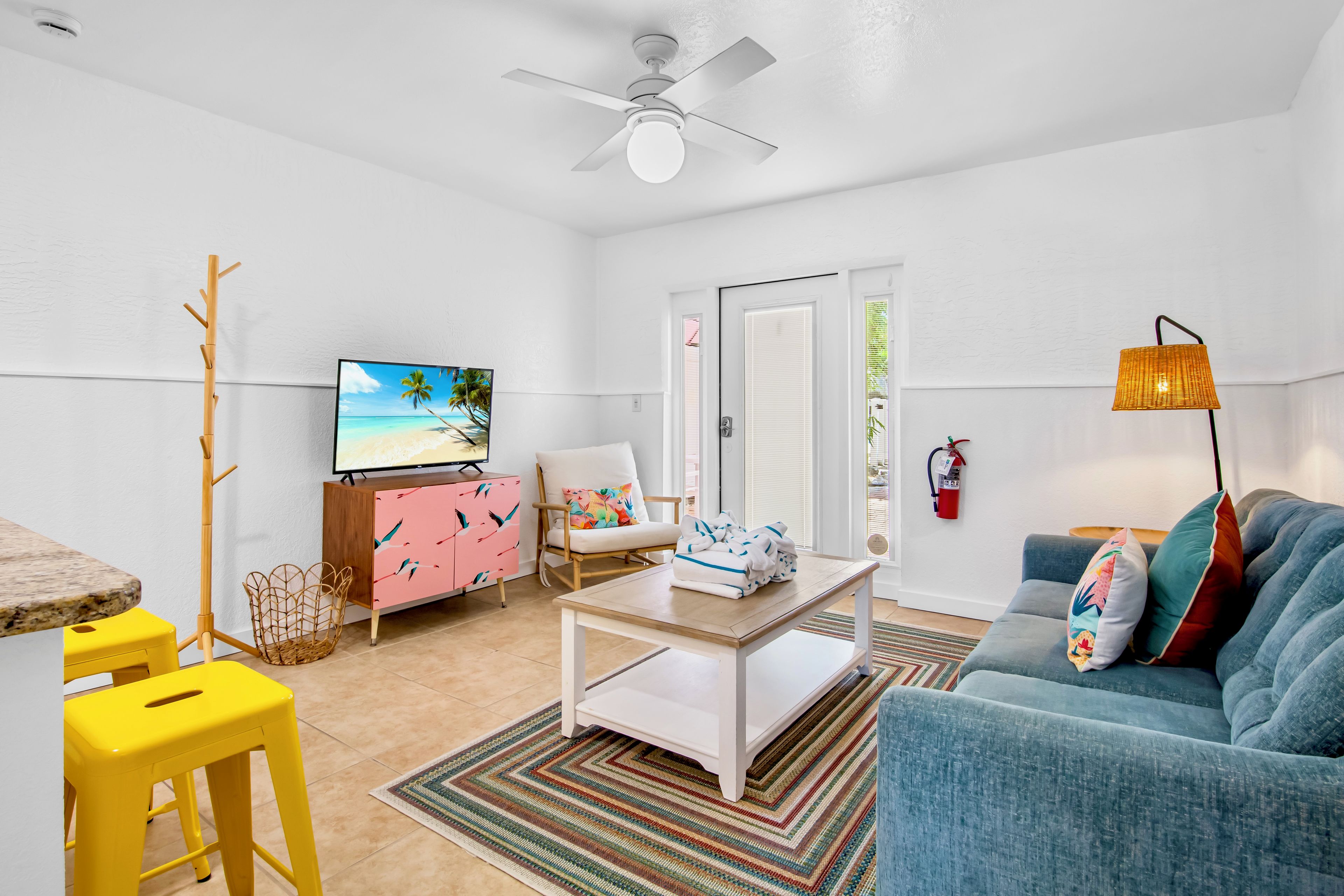 A modern living room with a television, a sofa, a coffee table, and a dining area.