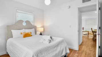 Un dormitorio con cama, mesita de noche, lámpara y ventilador de techo.