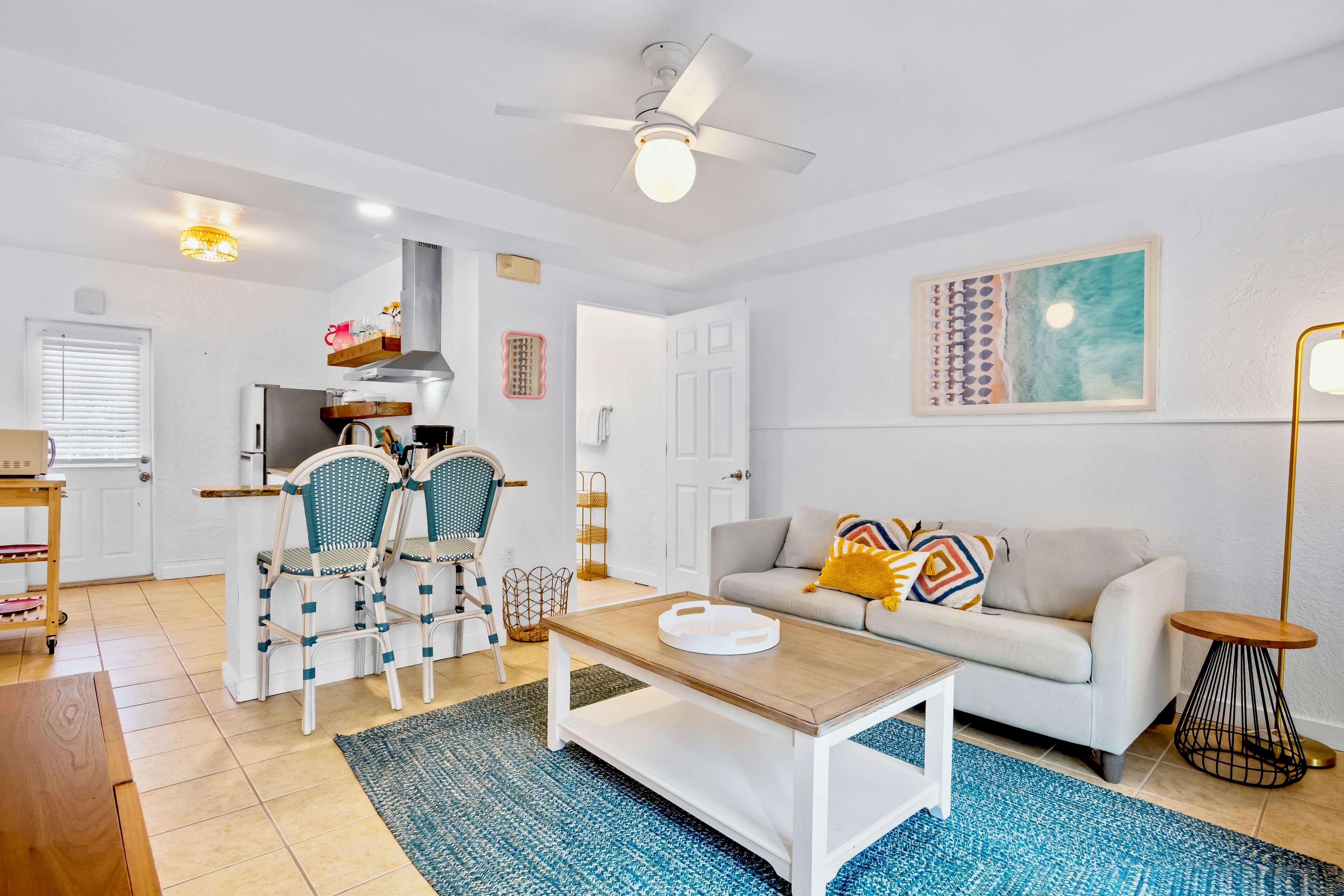 A modern living room with a sofa, a coffee table, and a dining area with chairs.