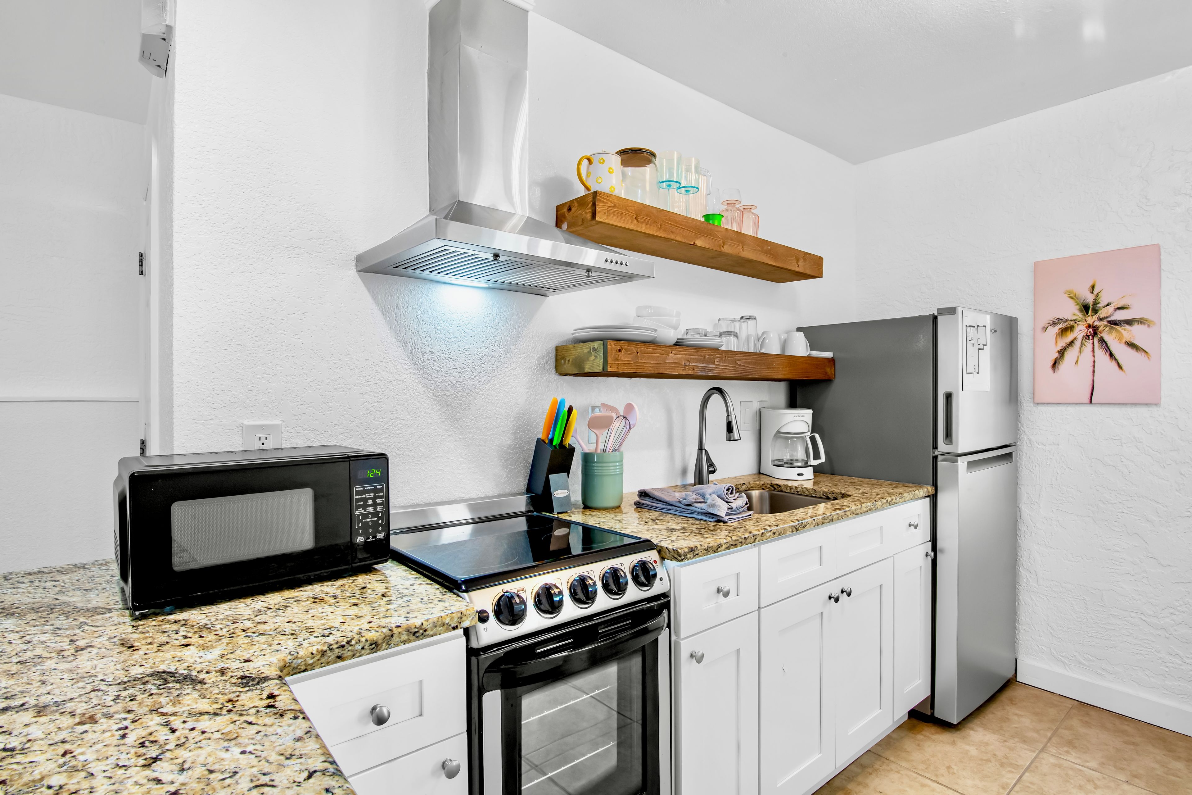 A compact kitchen with a microwave, stove, and refrigerator.