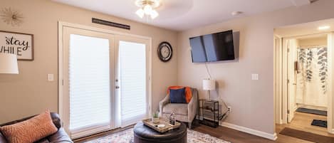 A living room with a leather sofa, ottoman, and a patterned rug.