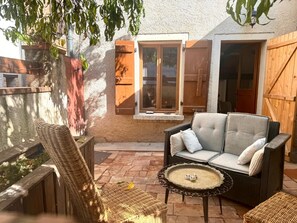 A patio with wicker furniture, a cushioned sofa, and a small table with candles.