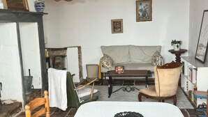 A cozy living room with a sofa, a coffee table, and a bed with a decorative headboard.