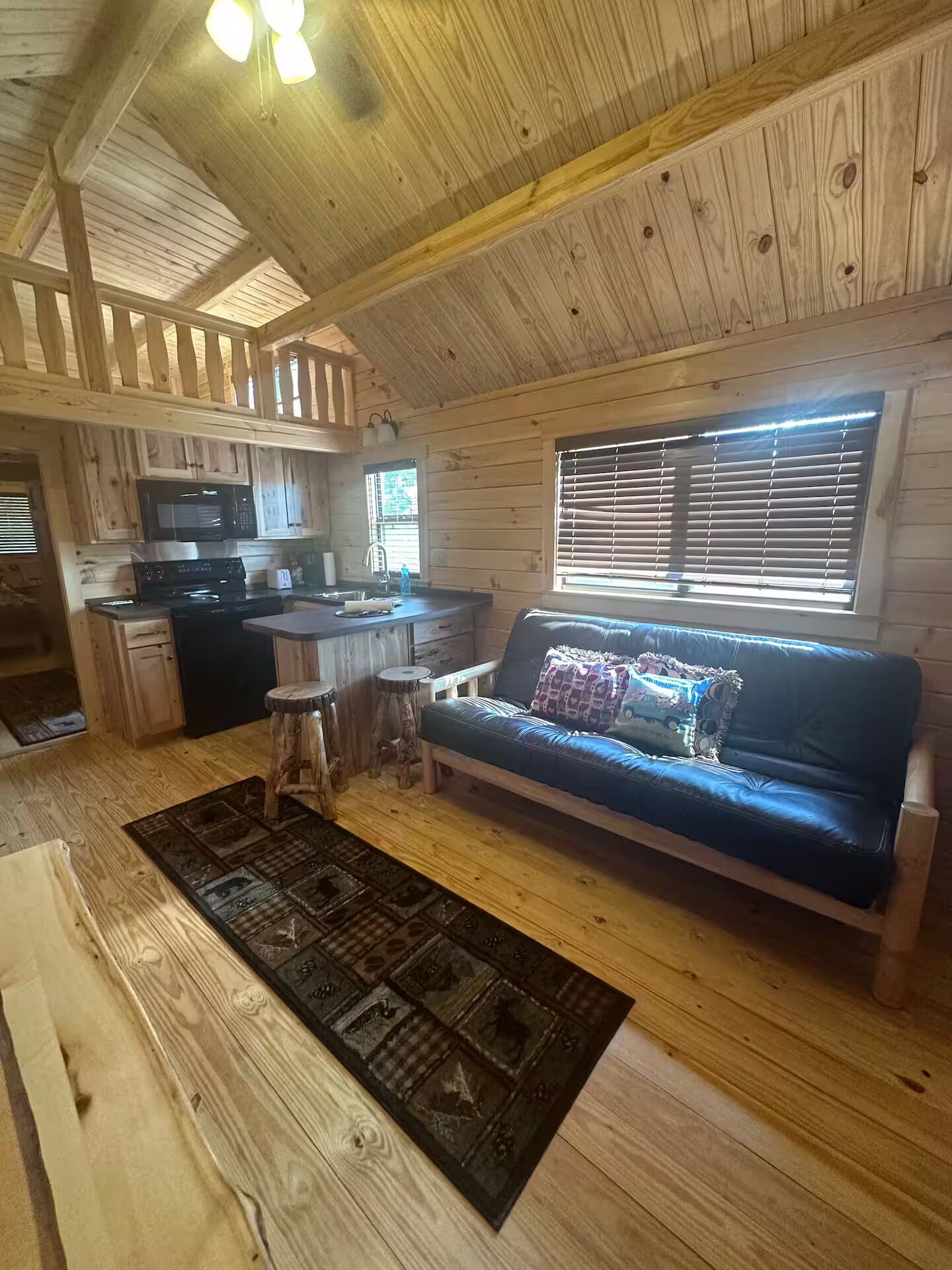 A cozy cabin interior with a kitchen, dining area, and a sofa.