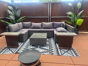 A sectional sofa with a matching ottoman and side tables, set on a patterned rug. - Trail Head Studio Suite (Village of Oak Creek)