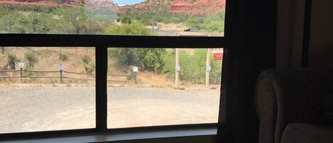 A room with a large window offering a view of red rock formations.