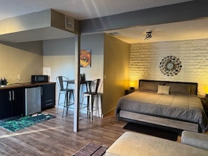 Ein gemütliches Schlafzimmer mit Bett, Nachttisch und Wanduhr.