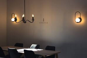 A conference room with a chandelier, a table, and four chairs. - Nature Getaway & Spa | Conifer (Notre-Dame-de-la-Merci)