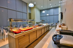 A buffet area with multiple food stations, a seating area with tables and chairs, and a counter with a cash register.
