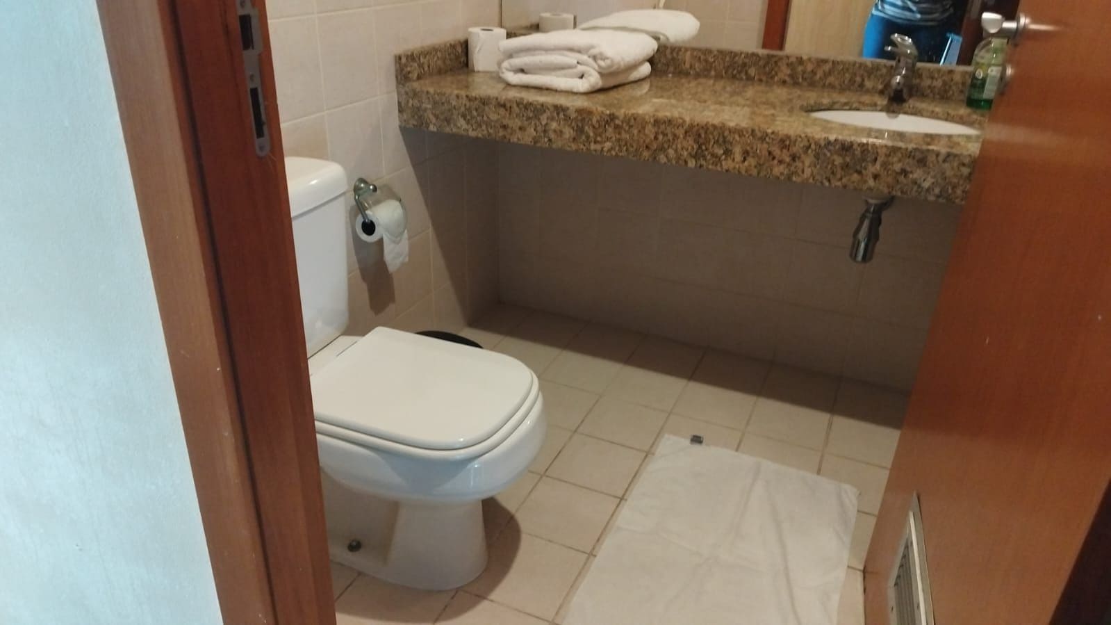 A bathroom with a toilet, a sink, and a mirror.