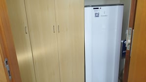 Une porte en bois, avec un réfrigérateur blanc sur le côté droit.