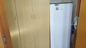 Une porte en bois, avec un réfrigérateur blanc sur le côté droit.