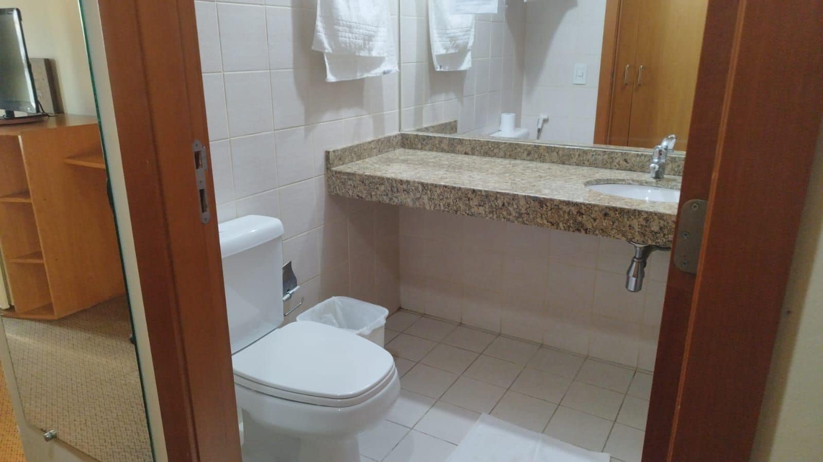 Un baño con inodoro, lavabo y espejo.