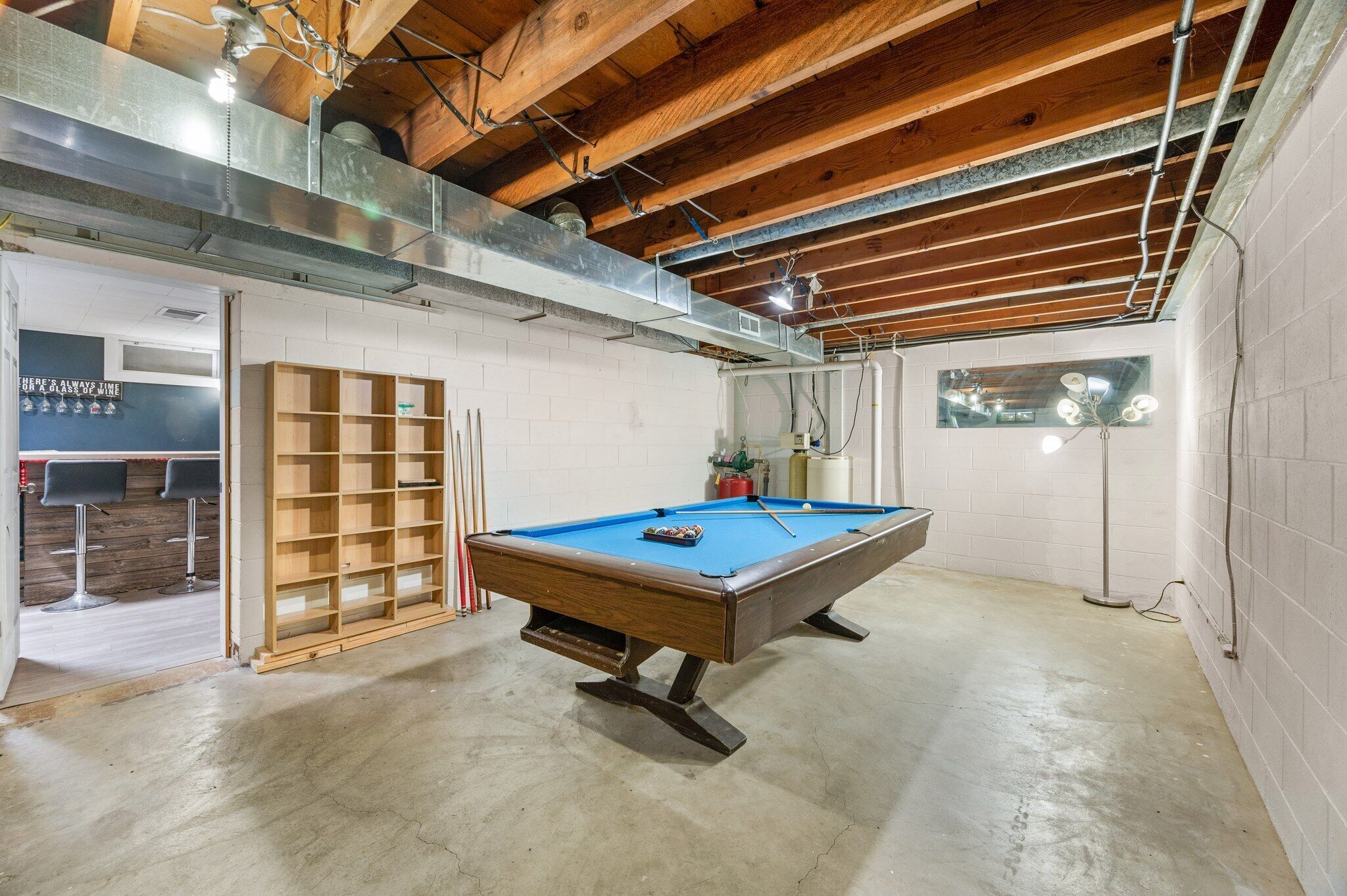 Une table de billard dans une pièce avec un plafond en bois et des murs blancs.