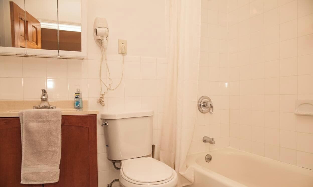 Een badkamer met toilet, wastafel en bad.