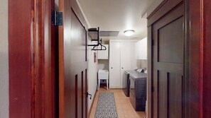 A narrow hallway with wooden doors, a small white sink, and a washing machine. - Timbers! Luxury 4+ Bdrm condo in this fantastic community on the golf course (Mammoth Lakes)