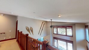 A spacious room with a high ceiling, wooden railing, and large windows allowing natural light. - Timbers! Luxury 4+ Bdrm condo in this fantastic community on the golf course (Mammoth Lakes)