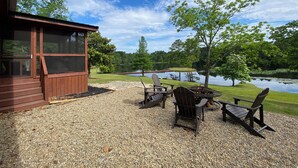 A wooden deck with outdoor seating and a view of a lake.