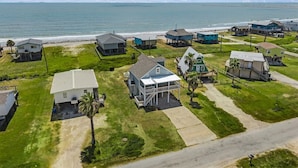 Une zone résidentielle côtière avec des maisons, une plage et un ciel dégagé.