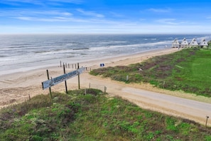 En strand med en skylt som visar att det är ”Surfside Beach”, och en stig som leder till strandhytterna.