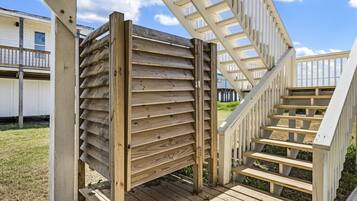 A wooden staircase leading to a deck area with a railing.