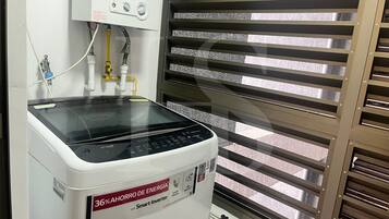 Un inversor inteligente blanco con pantalla digital y panel de control, conectado a un calentador de agua con tuberías.