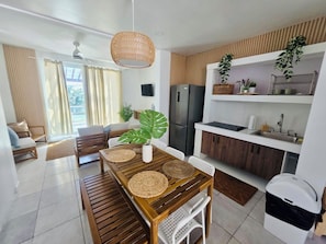 A modern kitchen with a built-in refrigerator, wooden cabinets, and a dining area with a wooden table and chairs. - 4-bedroom beach-front vacation home with private pool and BBQ (Patillas)