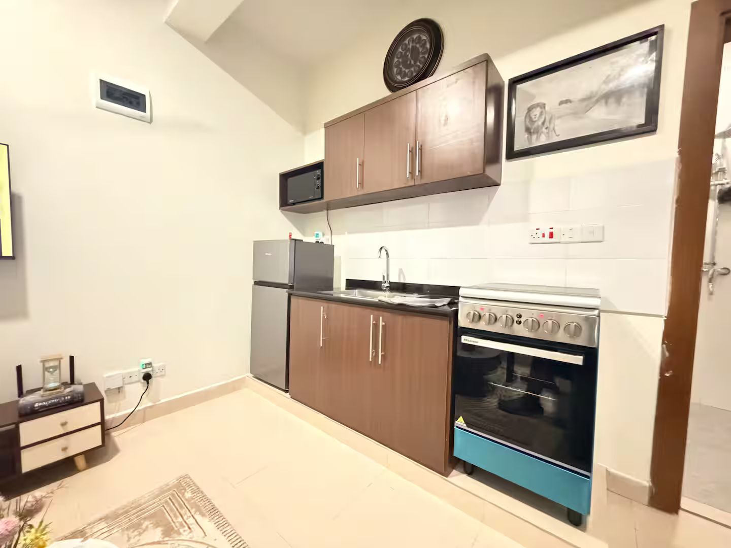 Cozinha compacta equipada com forno embutido, micro-ondas e frigorífico.