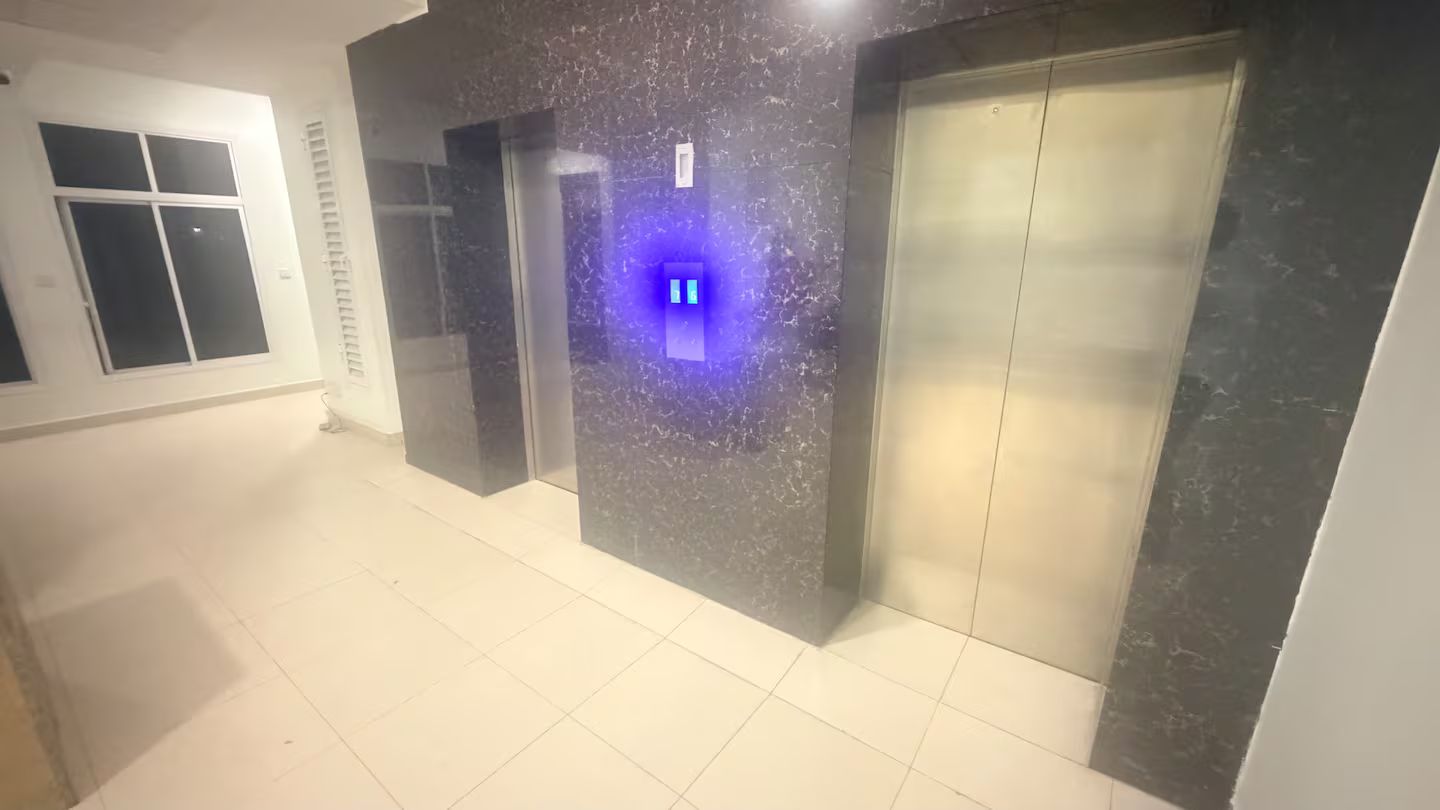Um elevador com painel de comando e parede de mármore.