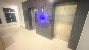 Un ascensor con panel de control y pared de mármol.