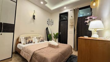 Un dormitorio con cama, mesita de noche, lámpara y espejo.