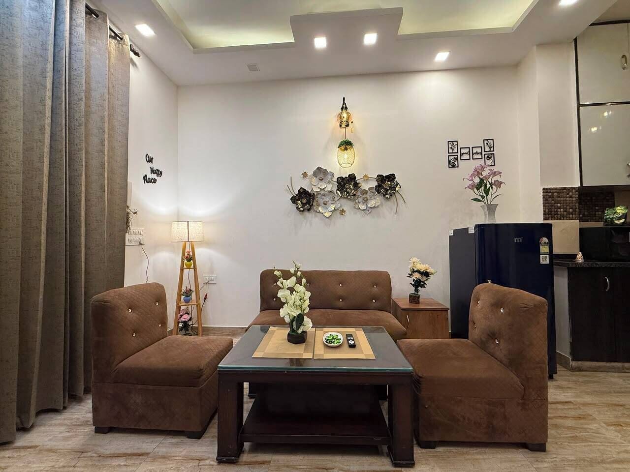 A modern living room with a sofa set, a coffee table, and a decorative wall piece.