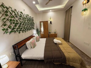 Un dormitorio con cama, mesita de noche, plantas en la pared, un espejo y un ventilador de techo.
