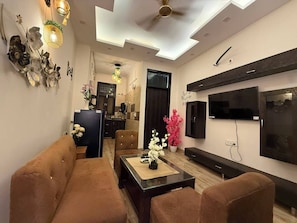 Una sala moderna con sofá, mesa de centro y televisor.