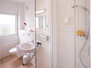 Un baño moderno con inodoro, lavabo y ducha.