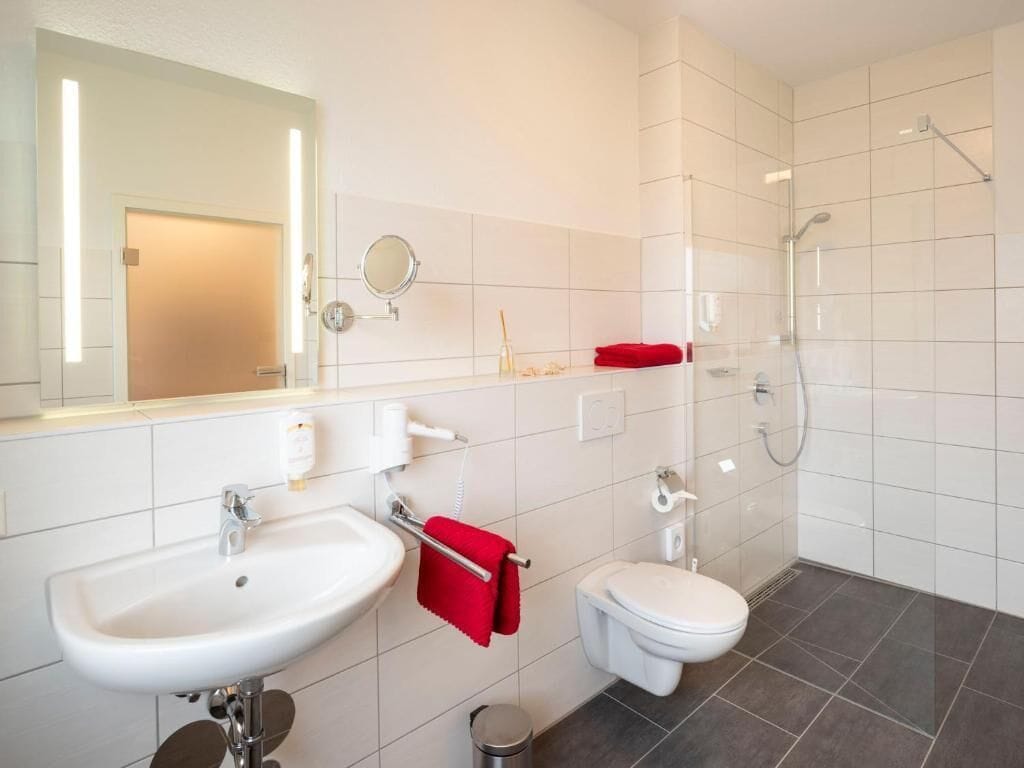 A modern bathroom with a sink, toilet, and shower.